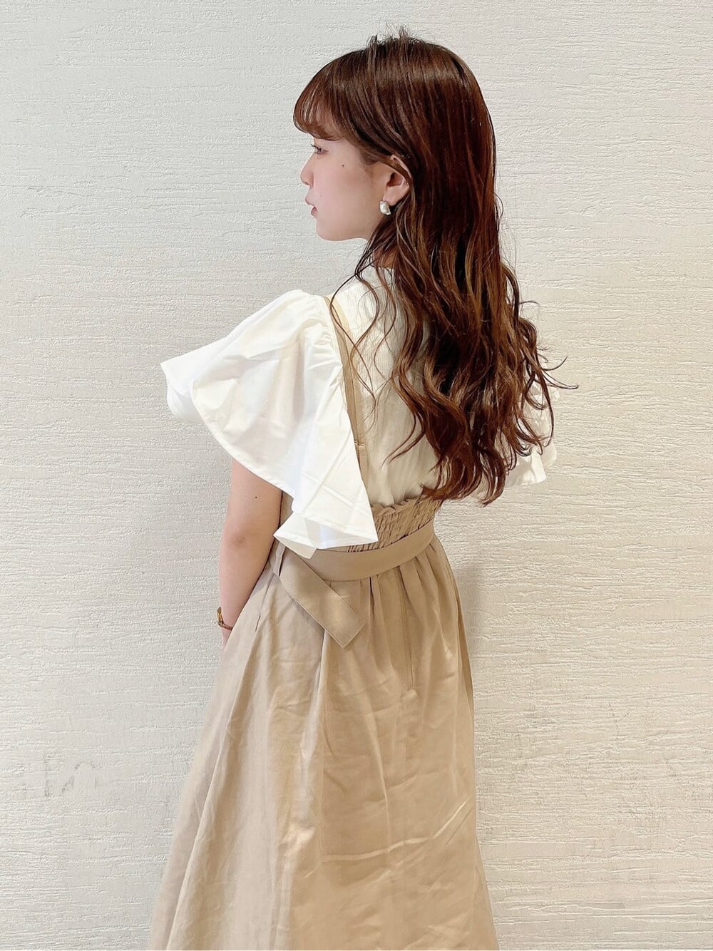 ベージュ系のサンダル、ベージュ系のワンピース、ホワイト系のTシャツ/カットソーを着用したレディースの春コーディネートの5枚目の写真