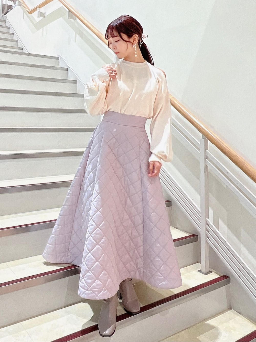 ホワイト系のニット/セーター、ピンク系のスカート、ベージュ系のブーツを着用したレディースの秋コーディネートの2枚目の写真