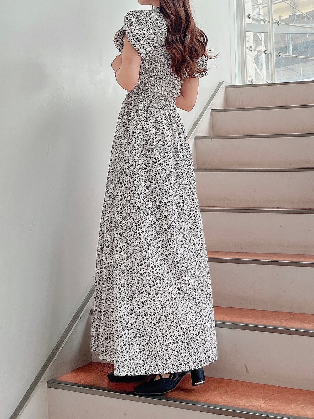 ホワイト系のワンピース、ブラック系のパンプスを着用したレディースの夏コーディネートの2枚目の写真