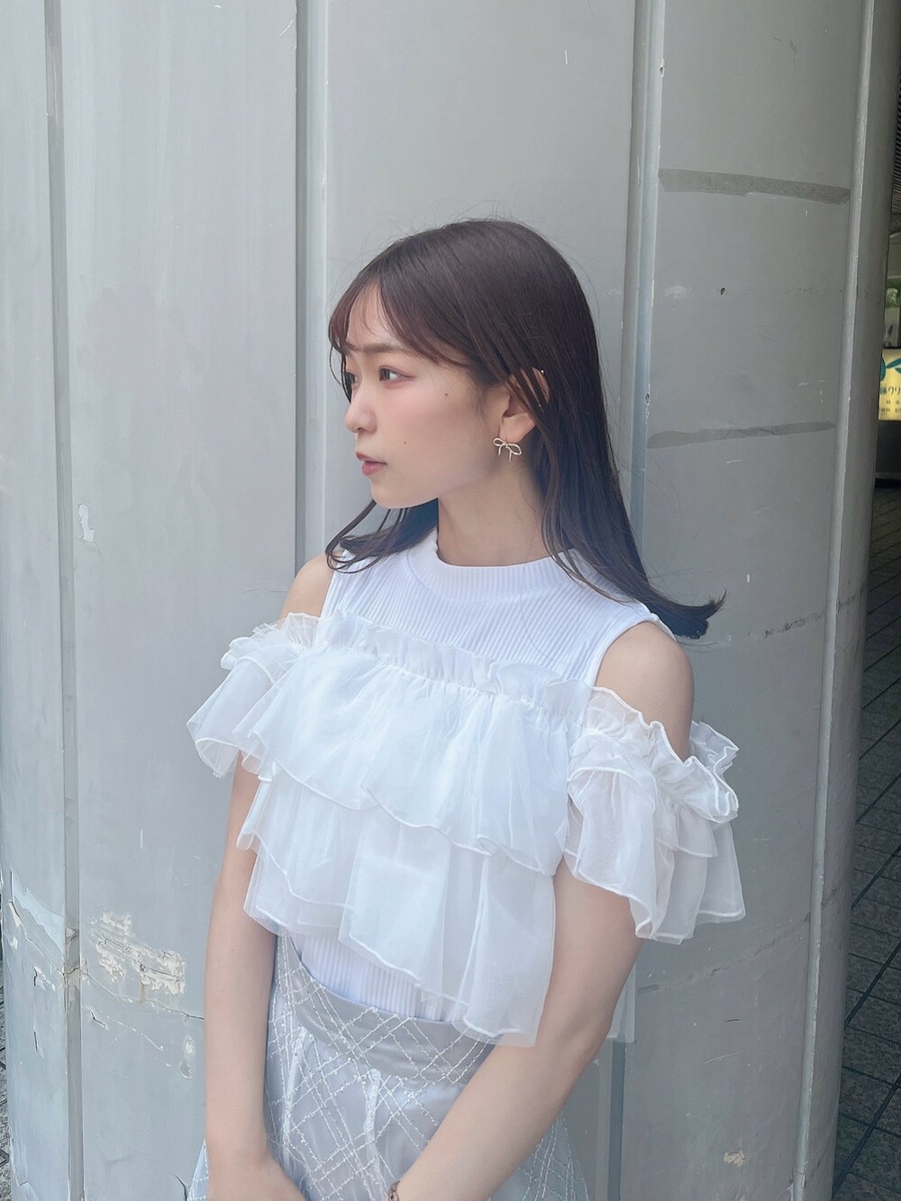 ホワイト系のTシャツ/カットソー、ホワイト系のパンプス、グレー系のスカートを着用したレディースの夏コーディネートの5枚目の写真