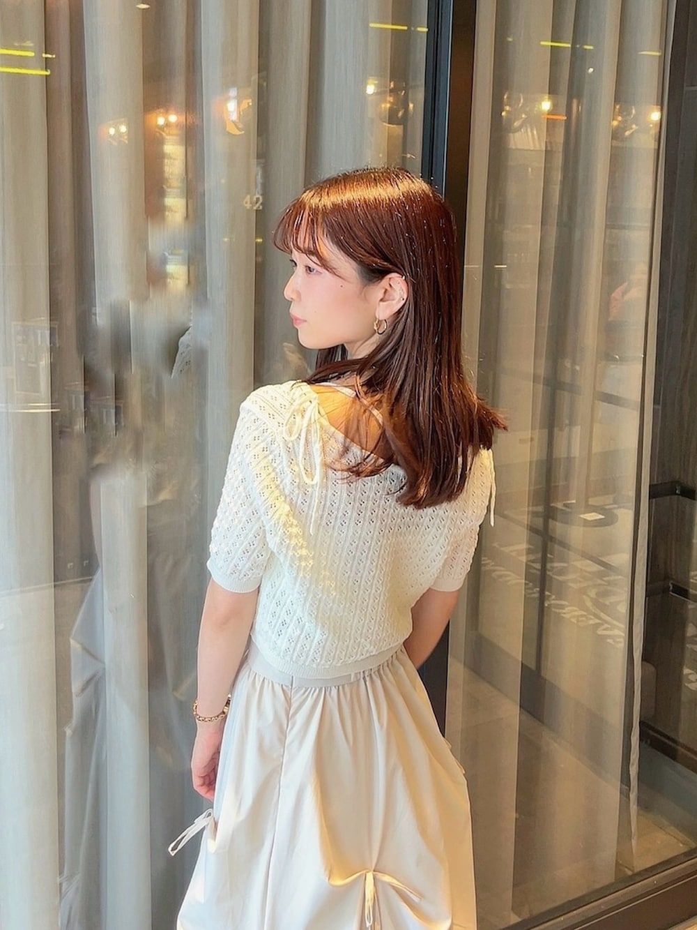 ホワイト系のニット/セーター、ホワイト系のスカートを着用したレディースの夏コーディネートの9枚目の写真