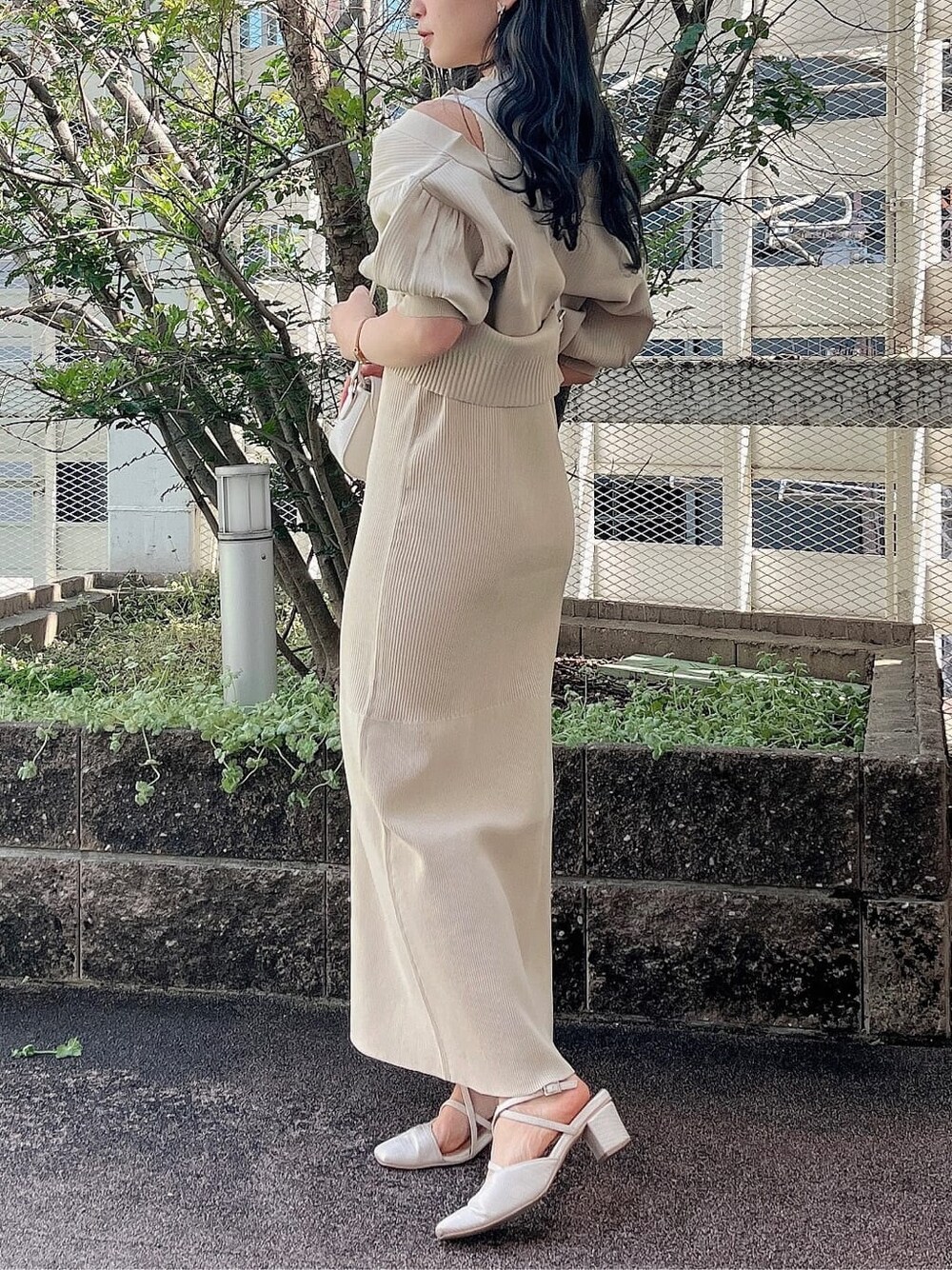ホワイト系のパンプス、ホワイト系のショルダーバッグ、ベージュ系のワンピースを着用したレディースの春コーディネートの2枚目の写真