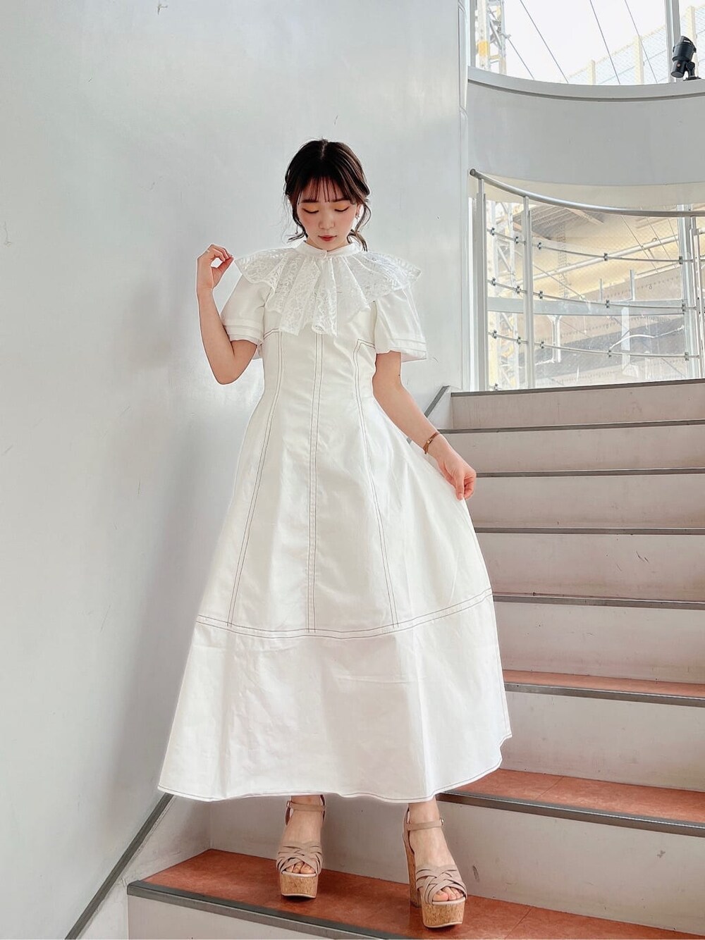 ベージュ系のサンダル、ホワイト系のワンピース、ホワイト系のシャツ/ブラウスを着用したレディースの春コーディネートの2枚目の写真