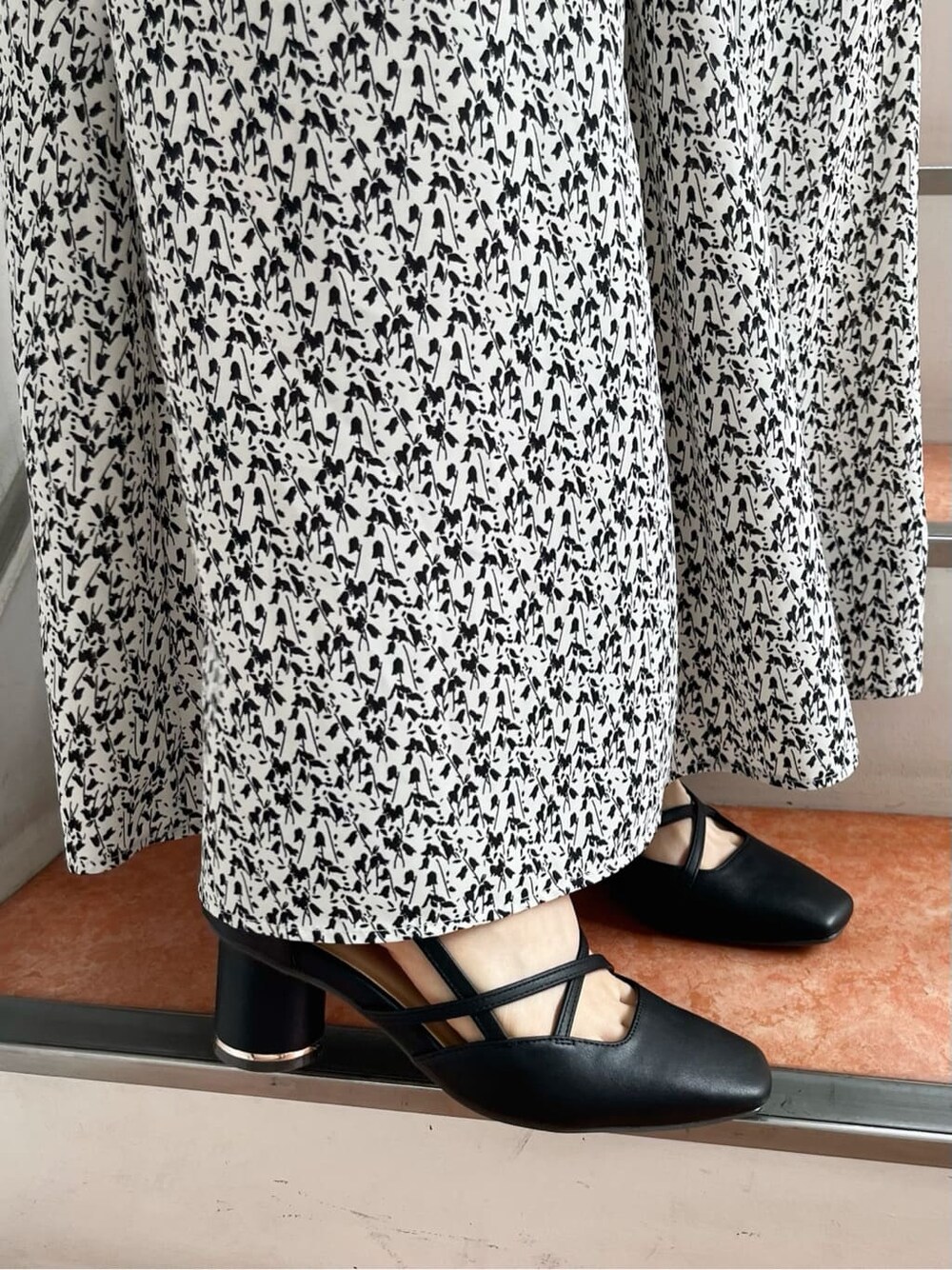 ホワイト系のワンピース、ブラック系のパンプスを着用したレディースの夏コーディネートの10枚目の写真