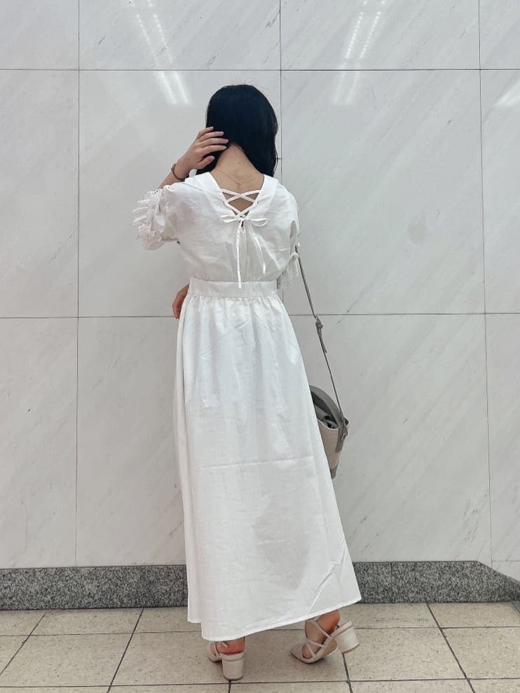 ホワイト系のワンピース、ホワイト系のパンプス、グレー系のハンドバッグを着用したレディースの春コーディネートの3枚目の写真