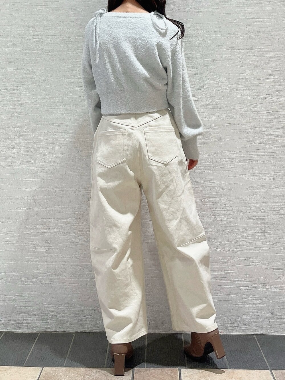 グレー系のキャミソール、グレー系のカーディガン/ボレロ、ホワイト系のデニムパンツを着用したレディースの冬コーディネートの4枚目の写真