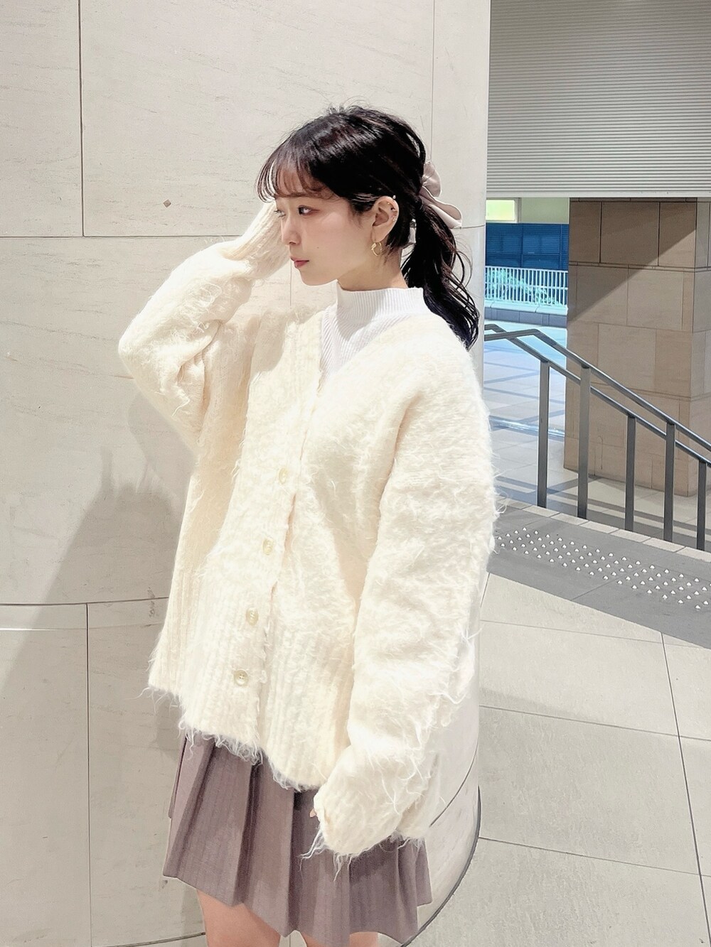 ホワイト系のニット/セーター、ホワイト系のカーディガン/ボレロ、ベージュ系のブーツを着用したレディースの冬コーディネートの5枚目の写真