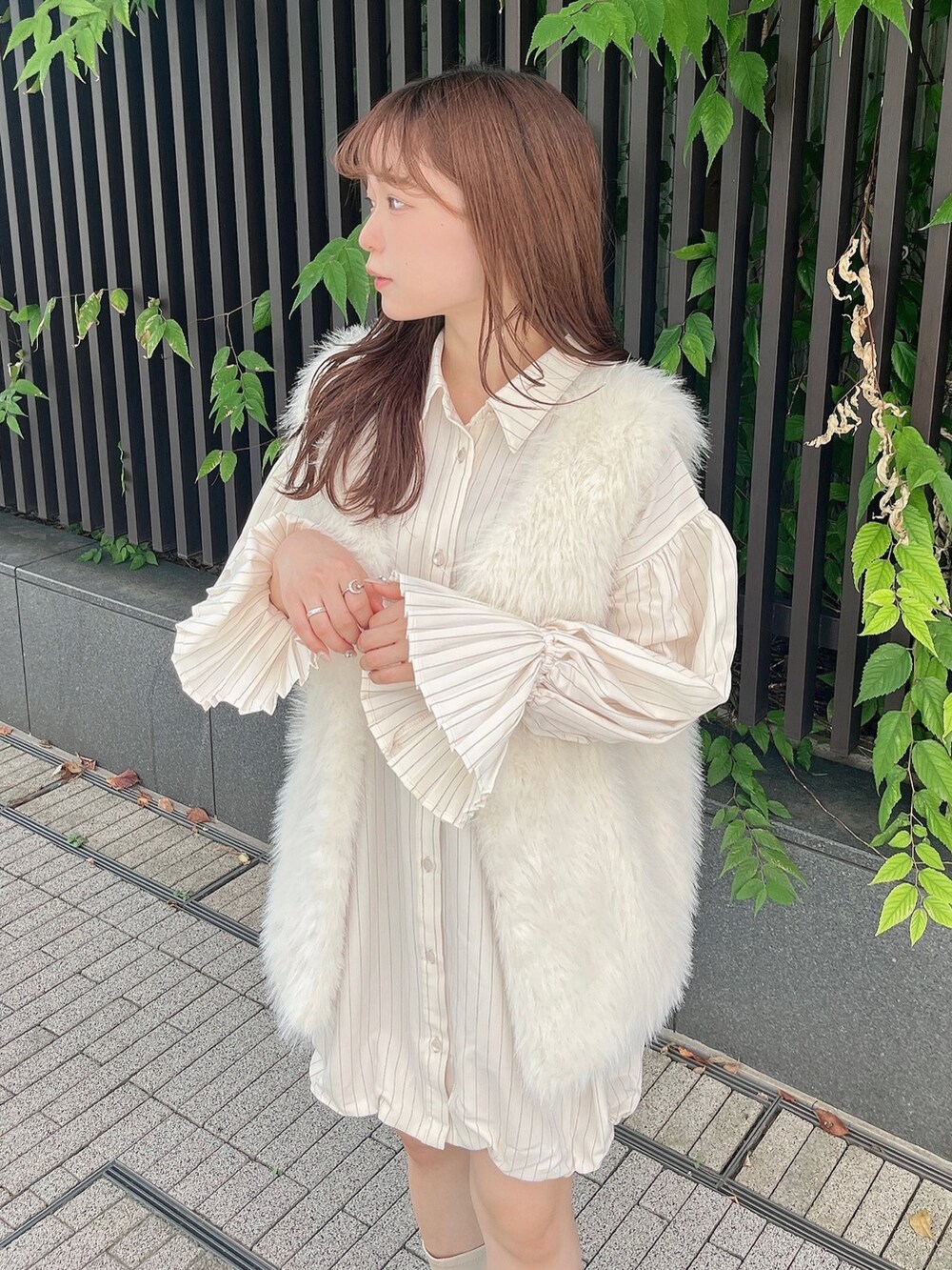 ホワイト系のベスト、ベージュ系のワンピース、ホワイト系のブーツを着用したレディースの秋コーディネートの10枚目の写真