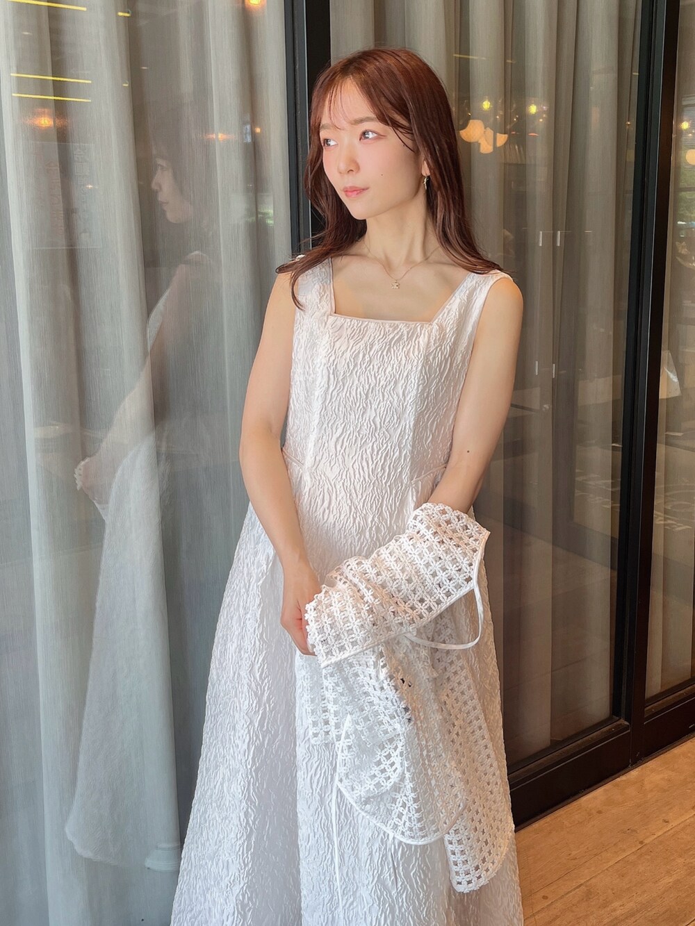 ホワイト系のドレス、ホワイト系のカーディガン/ボレロ、ホワイト系のサンダルを着用したレディースの夏コーディネートの6枚目の写真