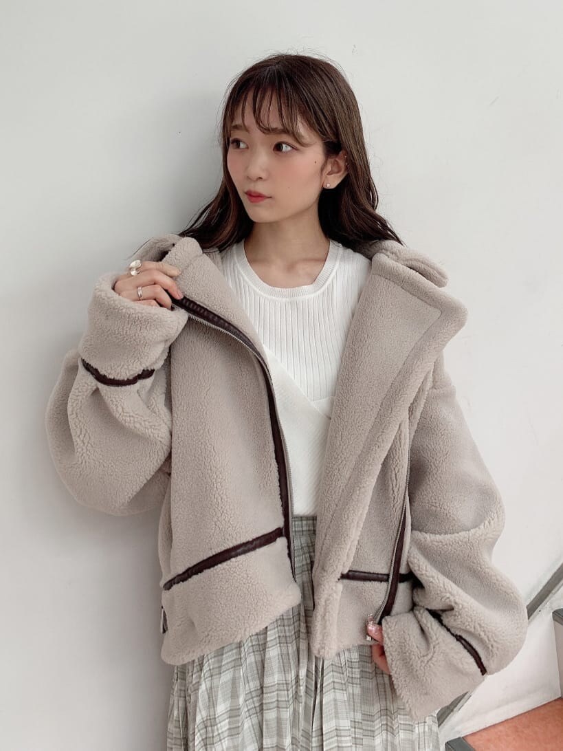 グリーン系のスカート、ホワイト系のニット/セーター、ベージュ系のブルゾンを着用したレディースの秋コーディネートの3枚目の写真