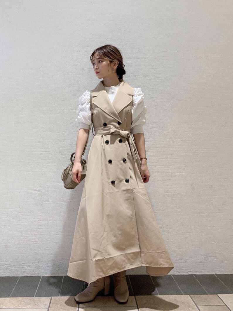 ベージュ系のワンピース、ベージュ系のブーツ、ホワイト系のニット/セーターを着用したレディースの秋コーディネートの3枚目の写真