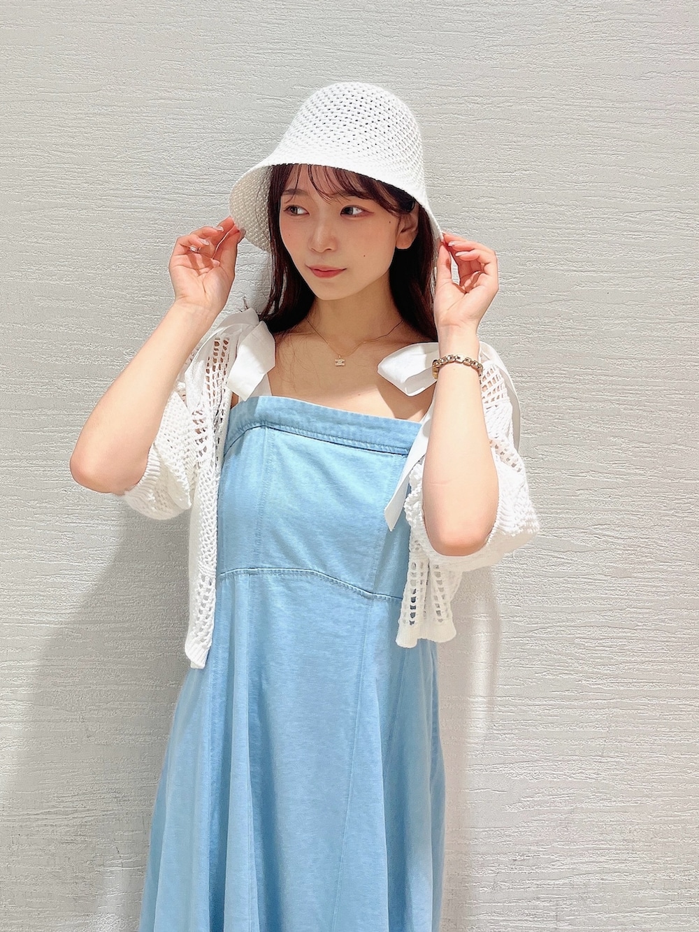 ホワイト系のカーディガン/ボレロ、ブルー系のワンピース、ホワイト系のパンプスを着用したレディースの夏コーディネートの7枚目の写真