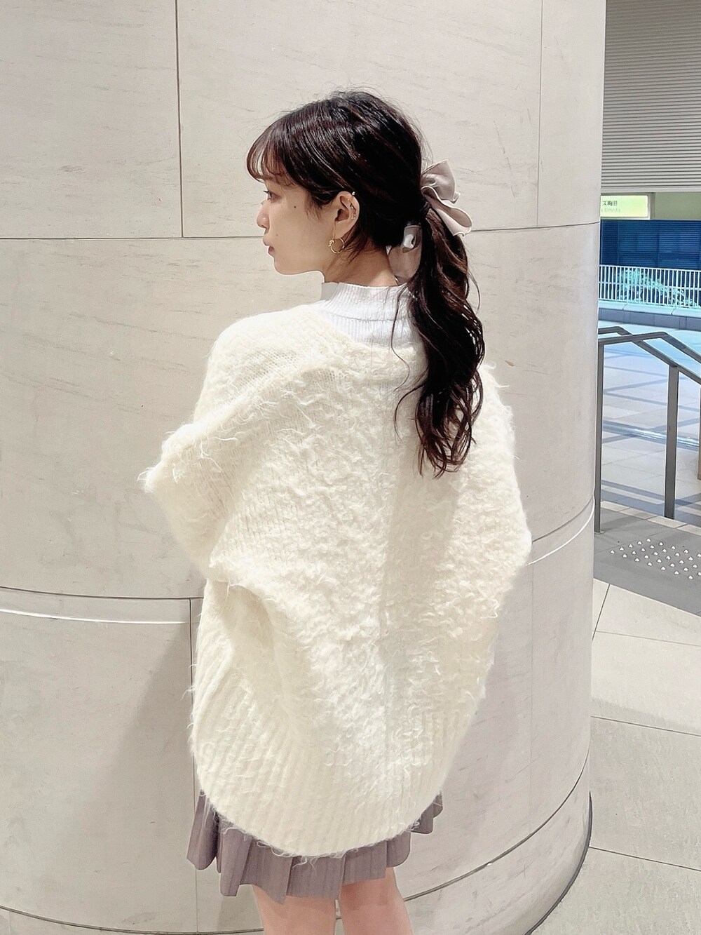 ホワイト系のニット/セーター、ホワイト系のカーディガン/ボレロ、ベージュ系のブーツを着用したレディースの冬コーディネートの7枚目の写真