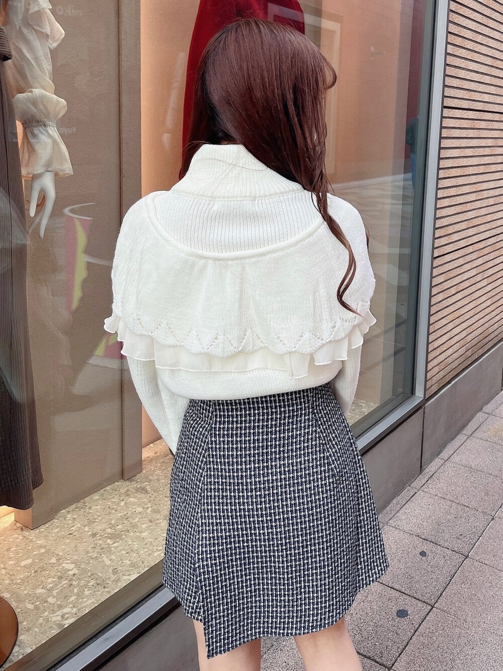 ホワイト系のニット/セーター、ブルー系のスカート、ブラック系のブーツを着用したレディースの秋コーディネートの6枚目の写真