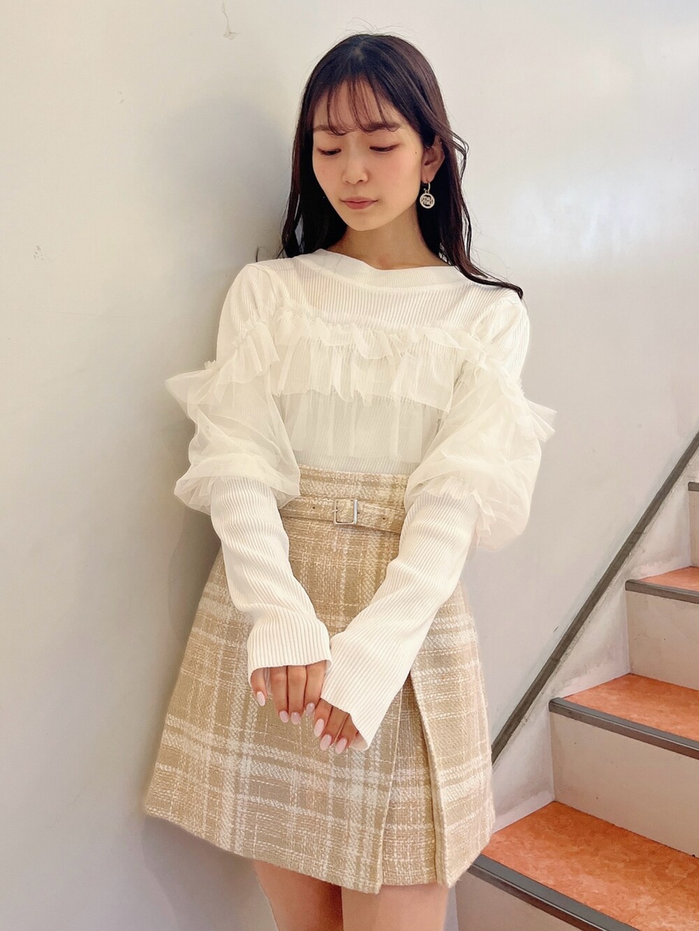 ホワイト系のニット/セーター、ベージュ系のスカート、ベージュ系のブーツを着用したレディースの冬コーディネートの6枚目の写真