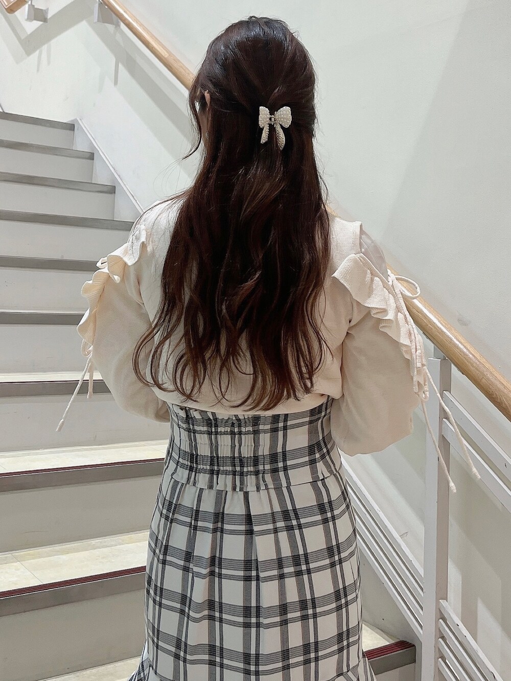 ホワイト系のニット/セーター、ホワイト系のスカート、ベージュ系のブーツを着用したレディースの冬コーディネートの7枚目の写真