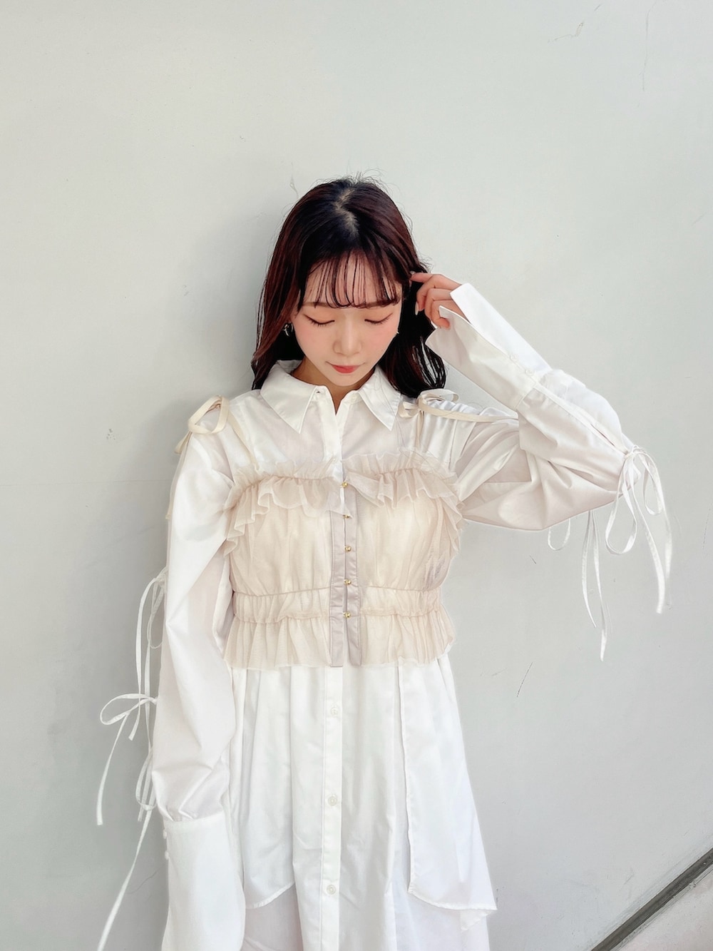 ベージュ系のキャミソール、ホワイト系のシャツワンピース、ホワイト系のブーツを着用したレディースの冬コーディネートの9枚目の写真