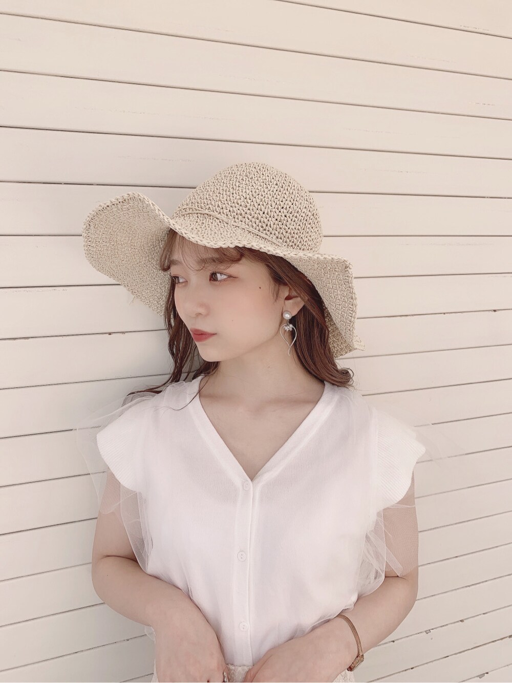 ホワイト系のスカート、ブラウン系のパンプス、ホワイト系のニット/セーターを着用したレディースの春コーディネートの7枚目の写真