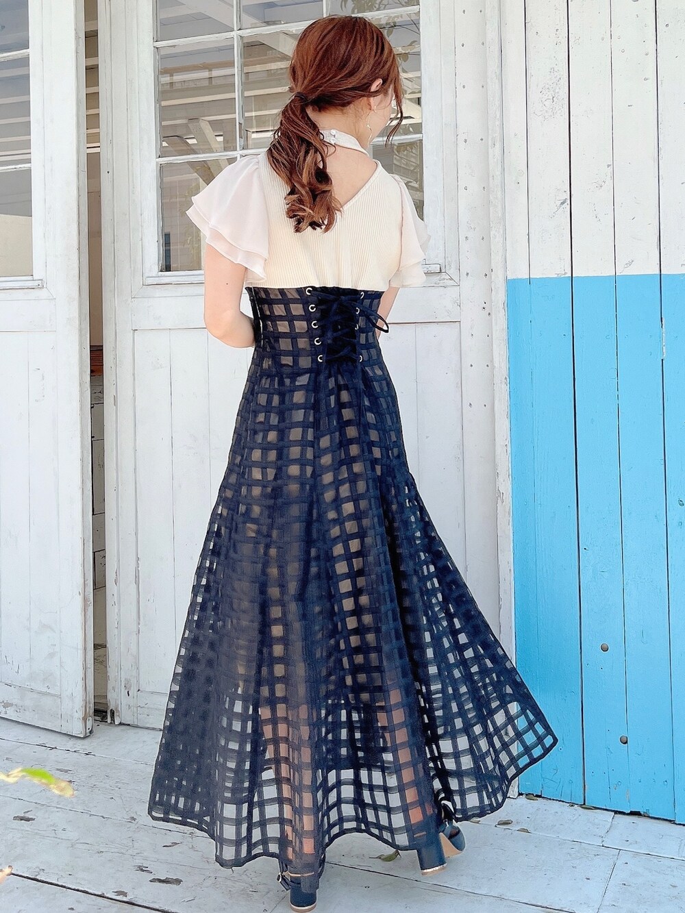 ホワイト系のワンピース、ブラック系のパンプスを着用したレディースの春コーディネートの3枚目の写真