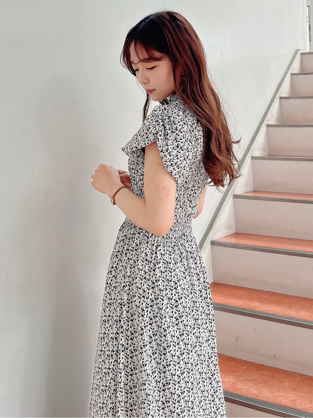 ホワイト系のワンピース、ブラック系のパンプスを着用したレディースの夏コーディネートの5枚目の写真