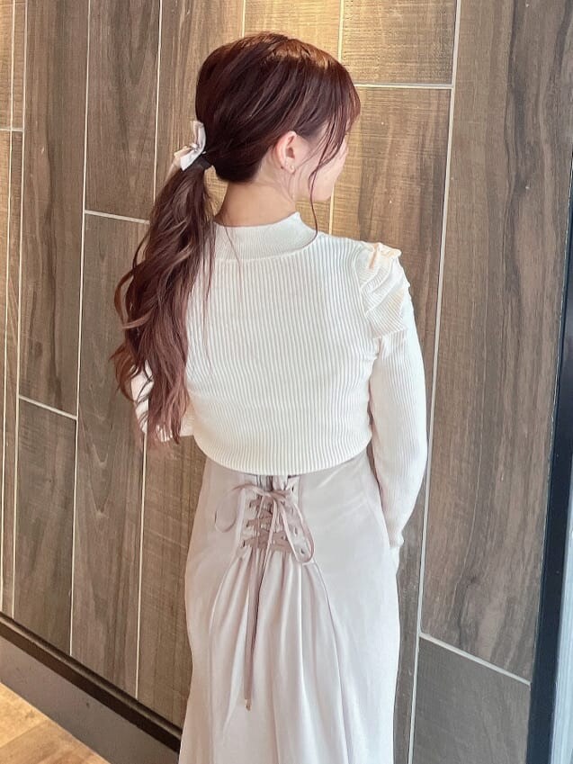 ベージュ系のブーツ、ベージュ系のスカート、ホワイト系のニット/セーターを着用したレディースの秋コーディネートの9枚目の写真