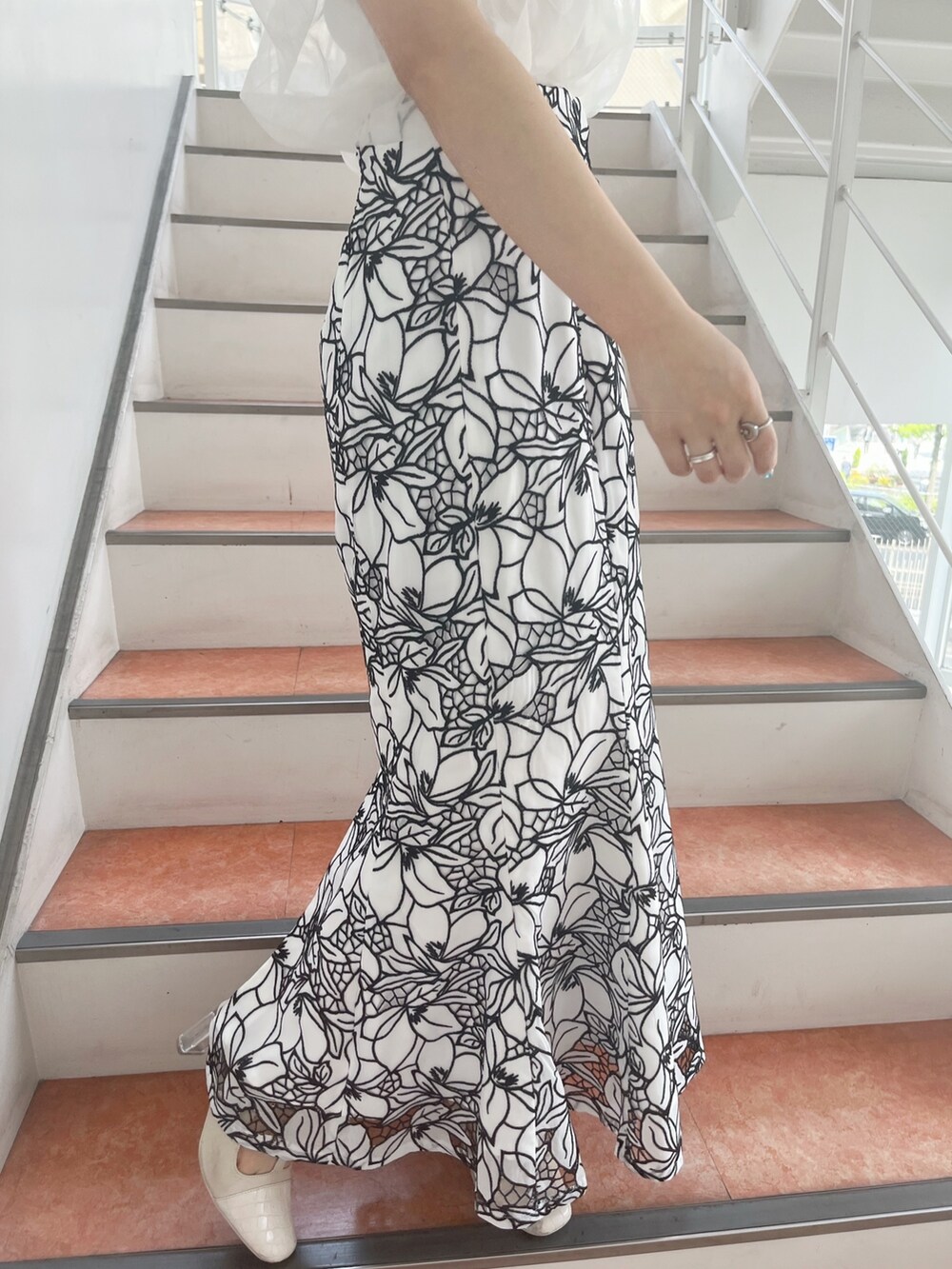 ホワイト系のパンプス、ホワイト系のスカート、ホワイト系のニット/セーターを着用したレディースの春コーディネートの9枚目の写真