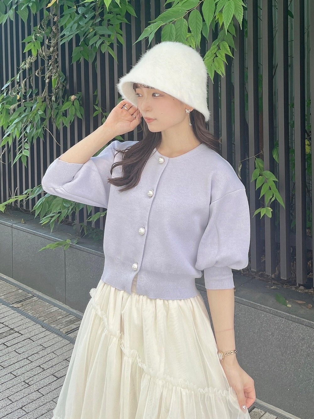 パープル系のカーディガン/ボレロ、ホワイト系のスカート、ホワイト系のブーツを着用したレディースの夏コーディネートの7枚目の写真