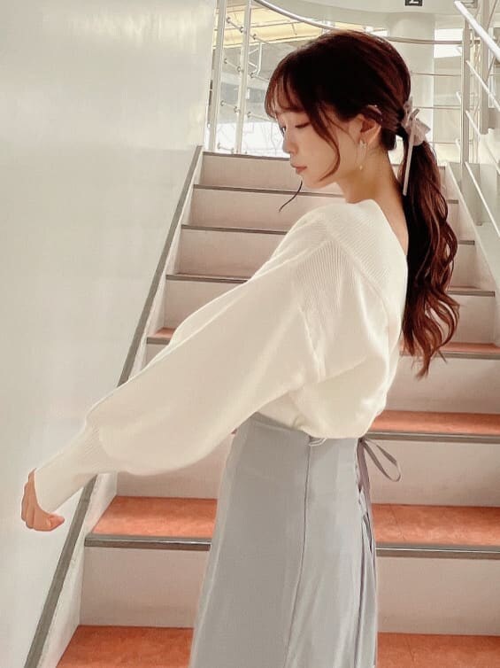 ベージュ系のブーツ、グレー系のスカート、ホワイト系のニット/セーターを着用したレディースの秋コーディネートの6枚目の写真