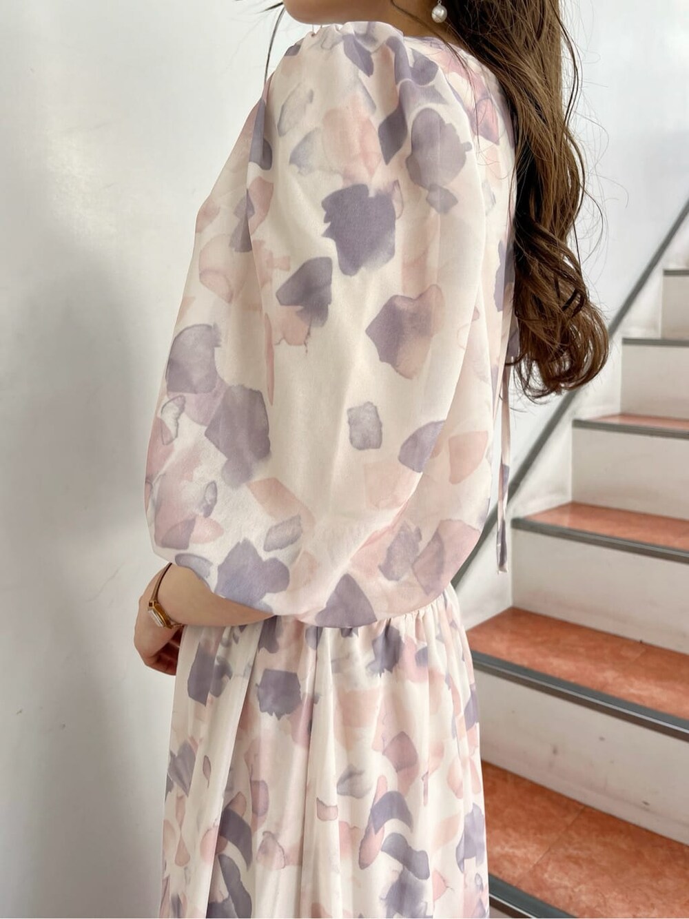 ピンク系のワンピース、ホワイト系のパンプス、ベージュ系のショルダーバッグを着用したレディースの春コーディネートの6枚目の写真