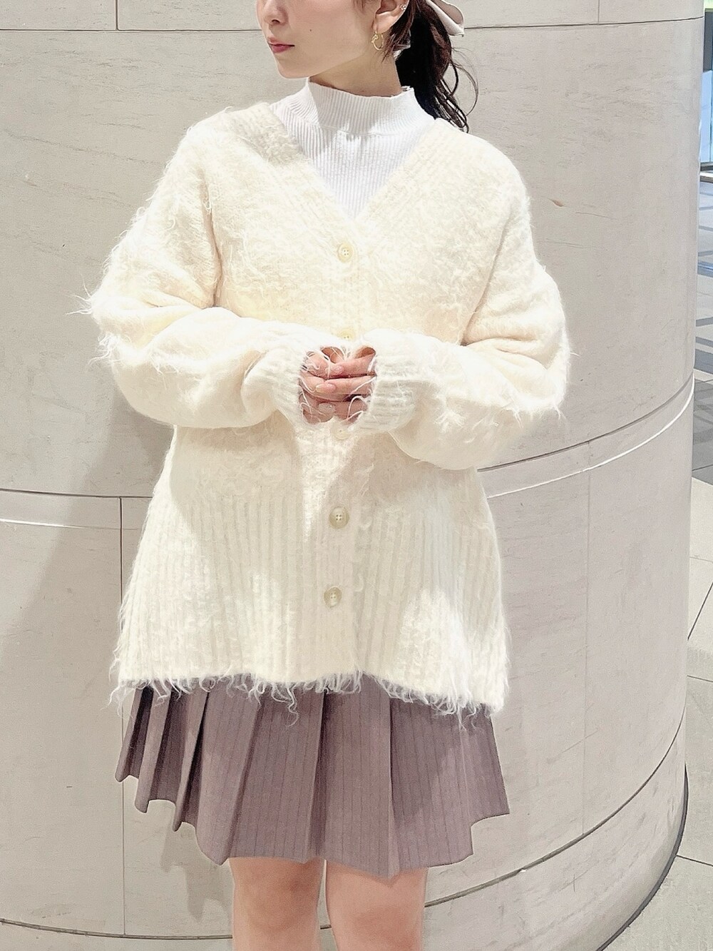 ホワイト系のニット/セーター、ホワイト系のカーディガン/ボレロ、ベージュ系のブーツを着用したレディースの冬コーディネートの6枚目の写真