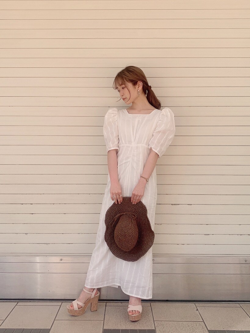 ホワイト系のワンピース、ベージュ系のサンダル、ブラウン系のハットを着用したレディースの春コーディネートの3枚目の写真