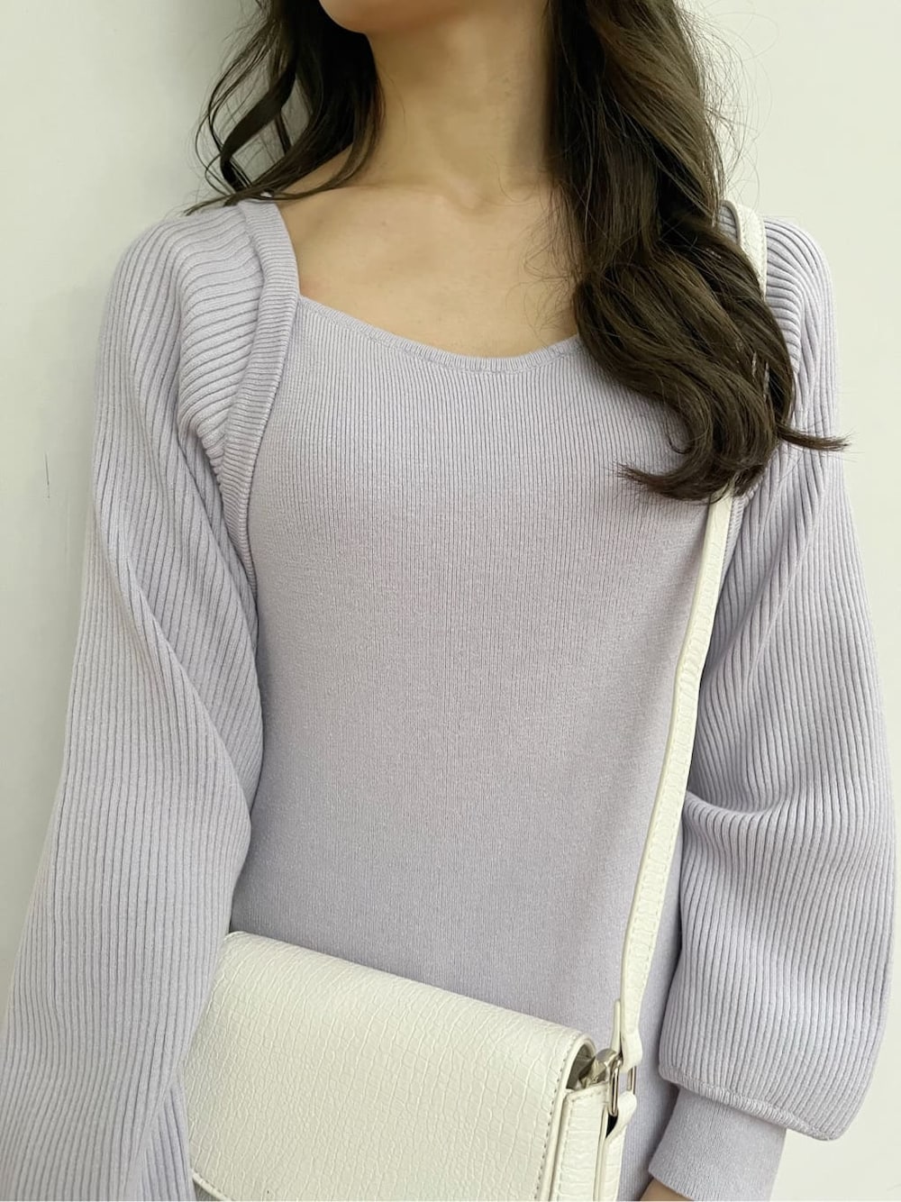 パープル系のワンピース、ブラック系のブーツ、ホワイト系のショルダーバッグを着用したレディースの冬コーディネートの7枚目の写真