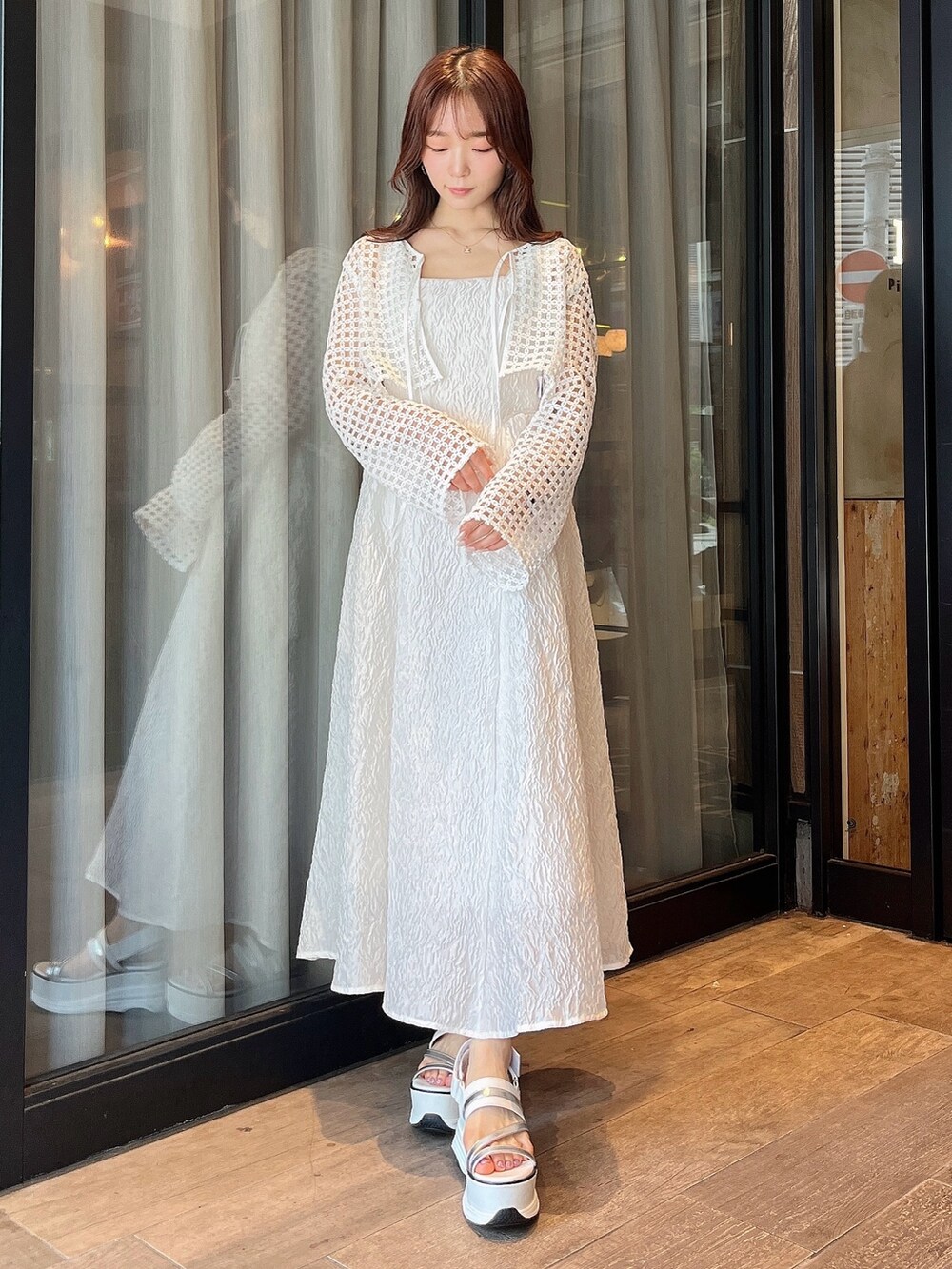 ホワイト系のドレス、ホワイト系のカーディガン/ボレロ、ホワイト系のサンダルを着用したレディースの夏コーディネートの2枚目の写真