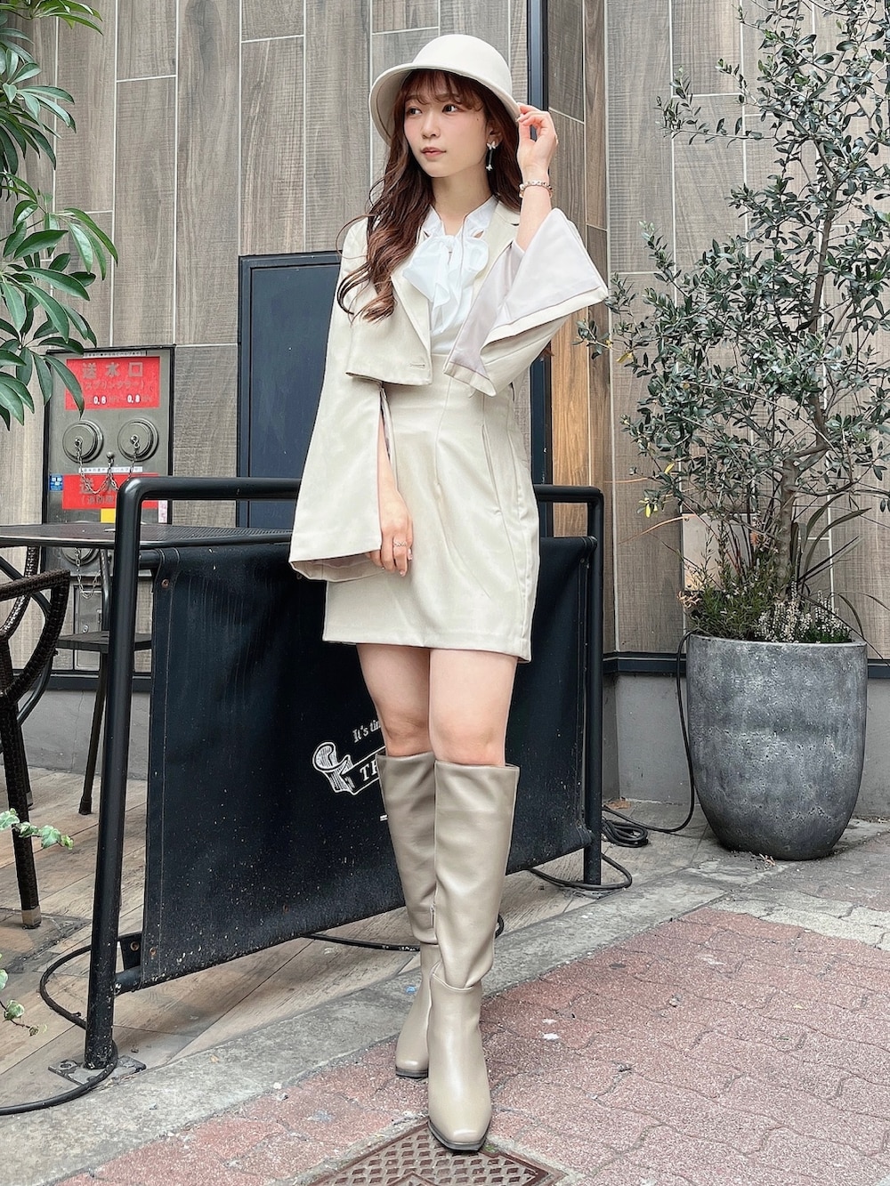 ベージュ系のテーラードジャケット、ホワイト系のニット/セーター、ベージュ系のスカートを着用したレディースの冬コーディネートの2枚目の写真