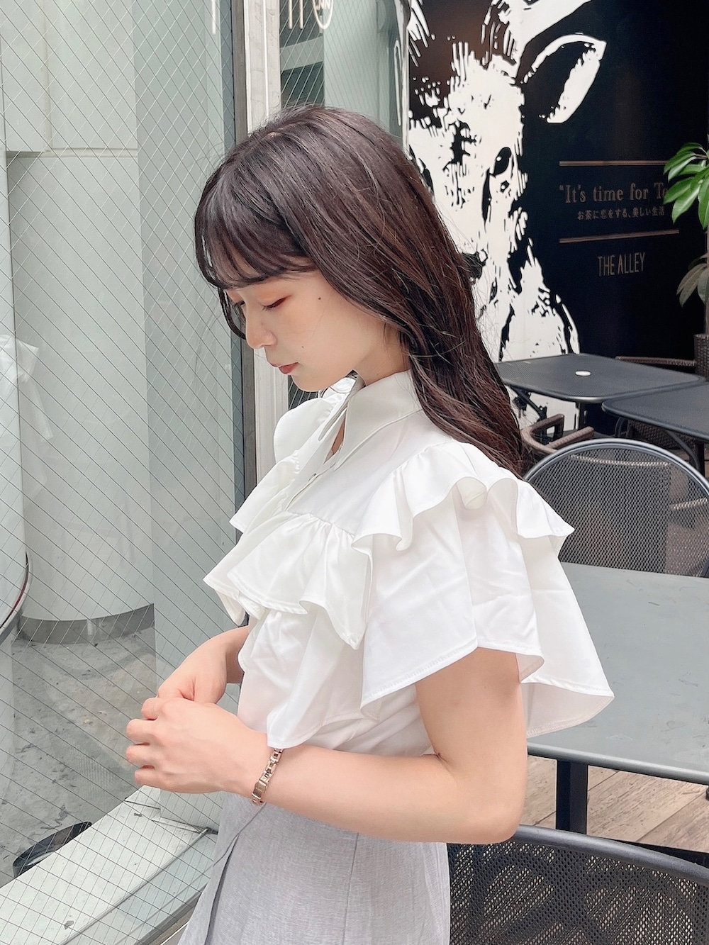 ホワイト系のシャツ/ブラウス、グレー系のスカート、ホワイト系のサンダルを着用したレディースの春コーディネートの8枚目の写真