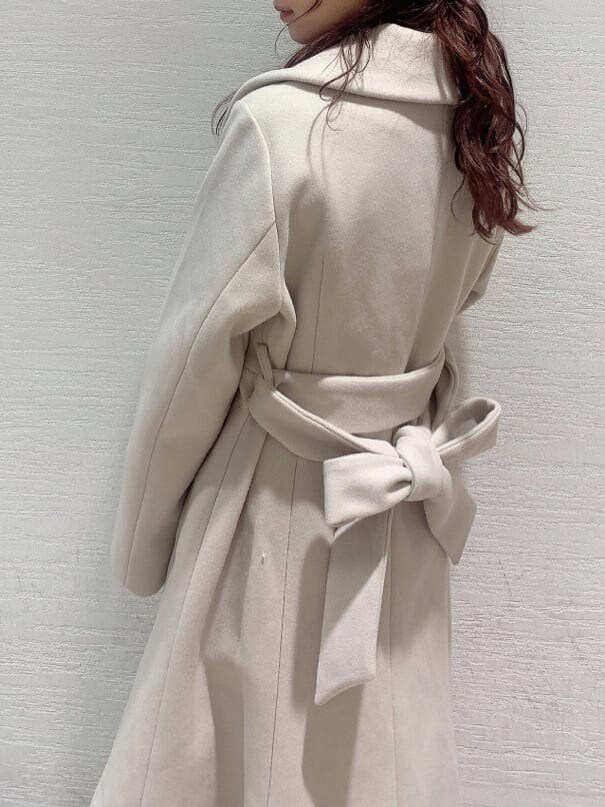 ホワイト系のその他アウター、ベージュ系のブーツ、ベージュ系のワンピースを着用したレディースの冬コーディネートの3枚目の写真