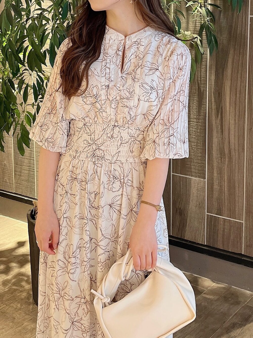 ベージュ系のサンダル、ホワイト系のハンドバッグ、ホワイト系のワンピースを着用したレディースの春コーディネートの4枚目の写真