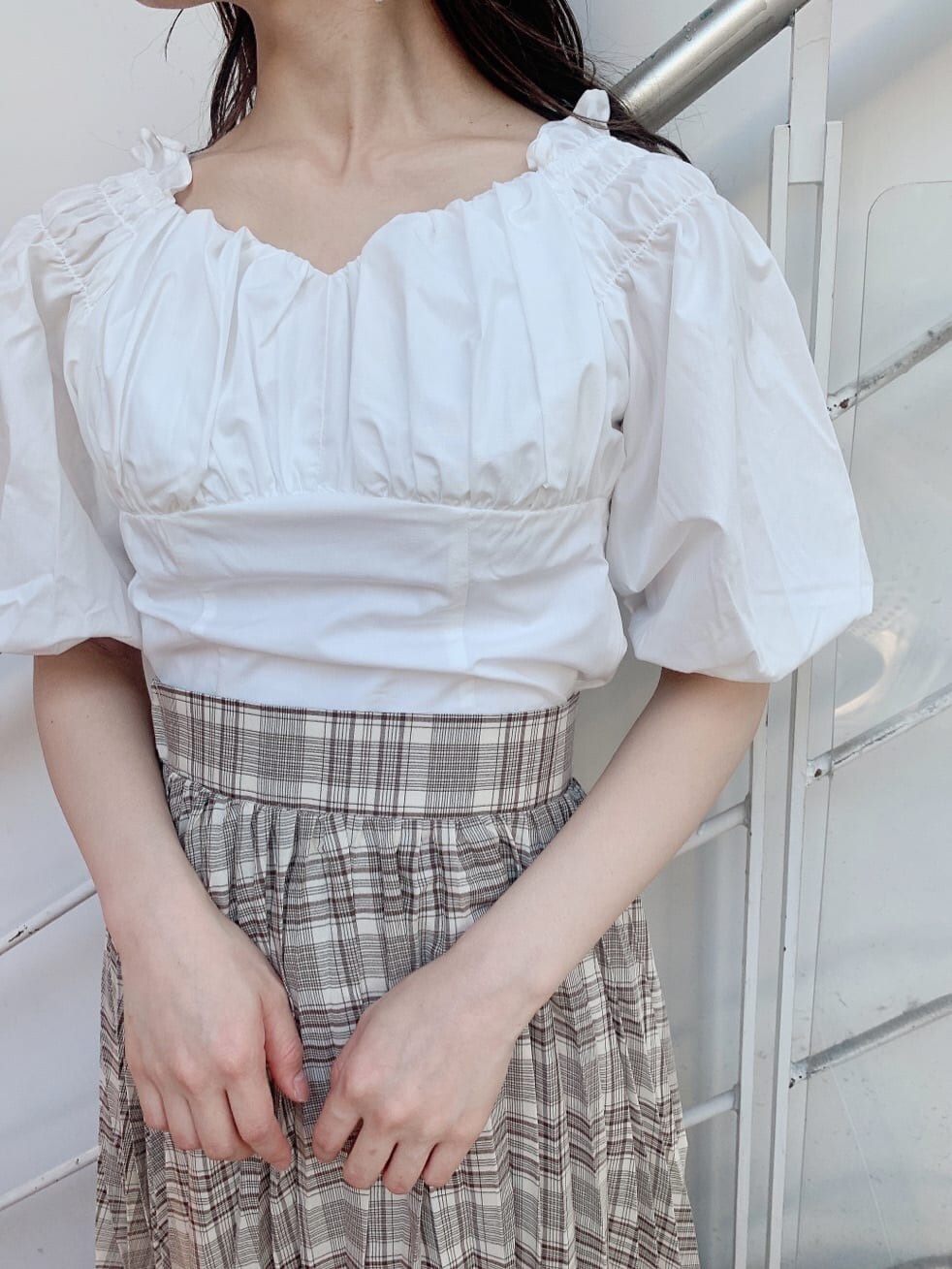 ホワイト系のシャツ/ブラウス、ベージュ系のスカート、ホワイト系のパンプスを着用したレディースの夏コーディネートの4枚目の写真