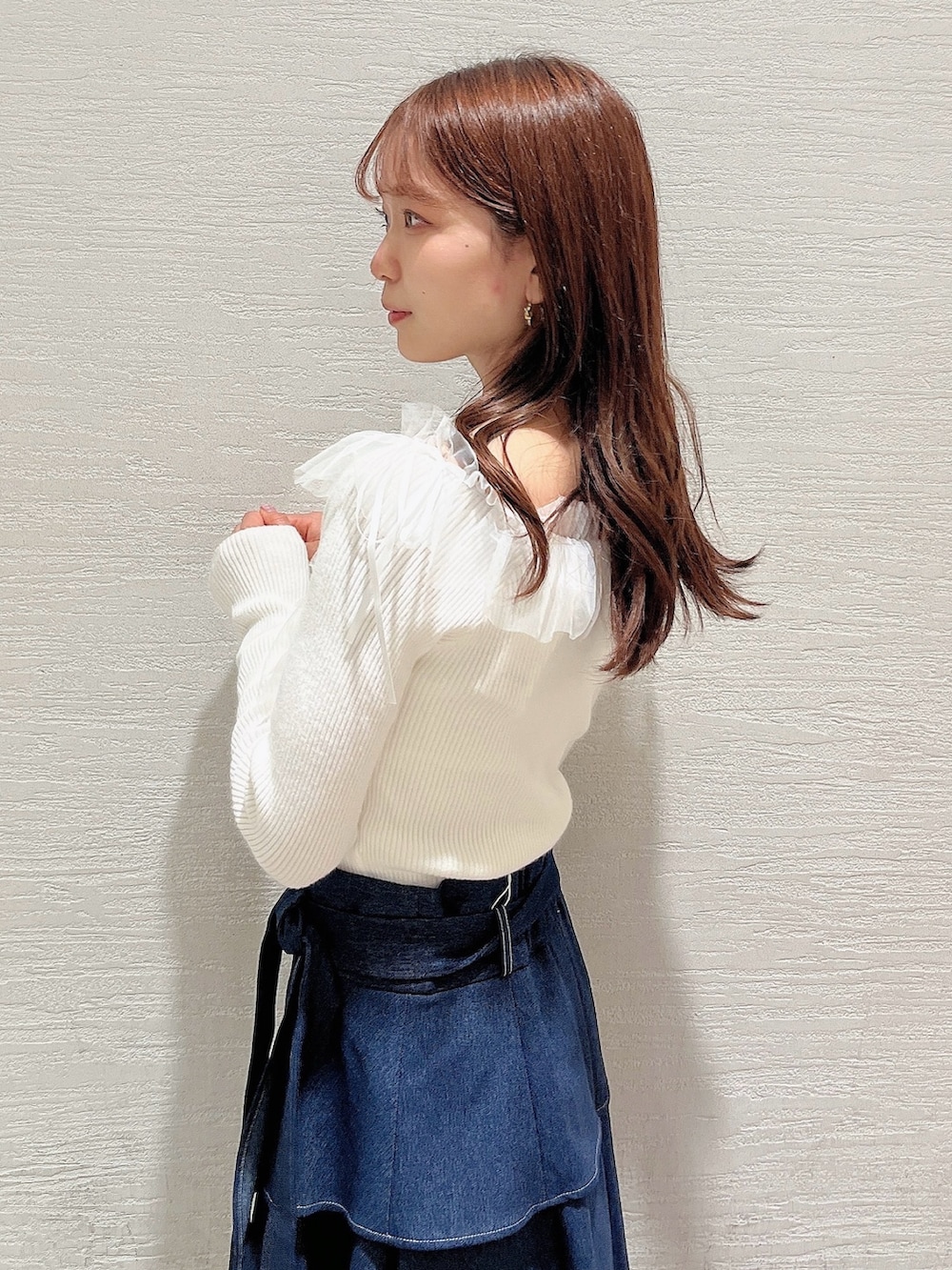 ベージュ系のパンプス、ブルー系のスカート、ホワイト系のニット/セーターを着用したレディースの秋コーディネートの6枚目の写真