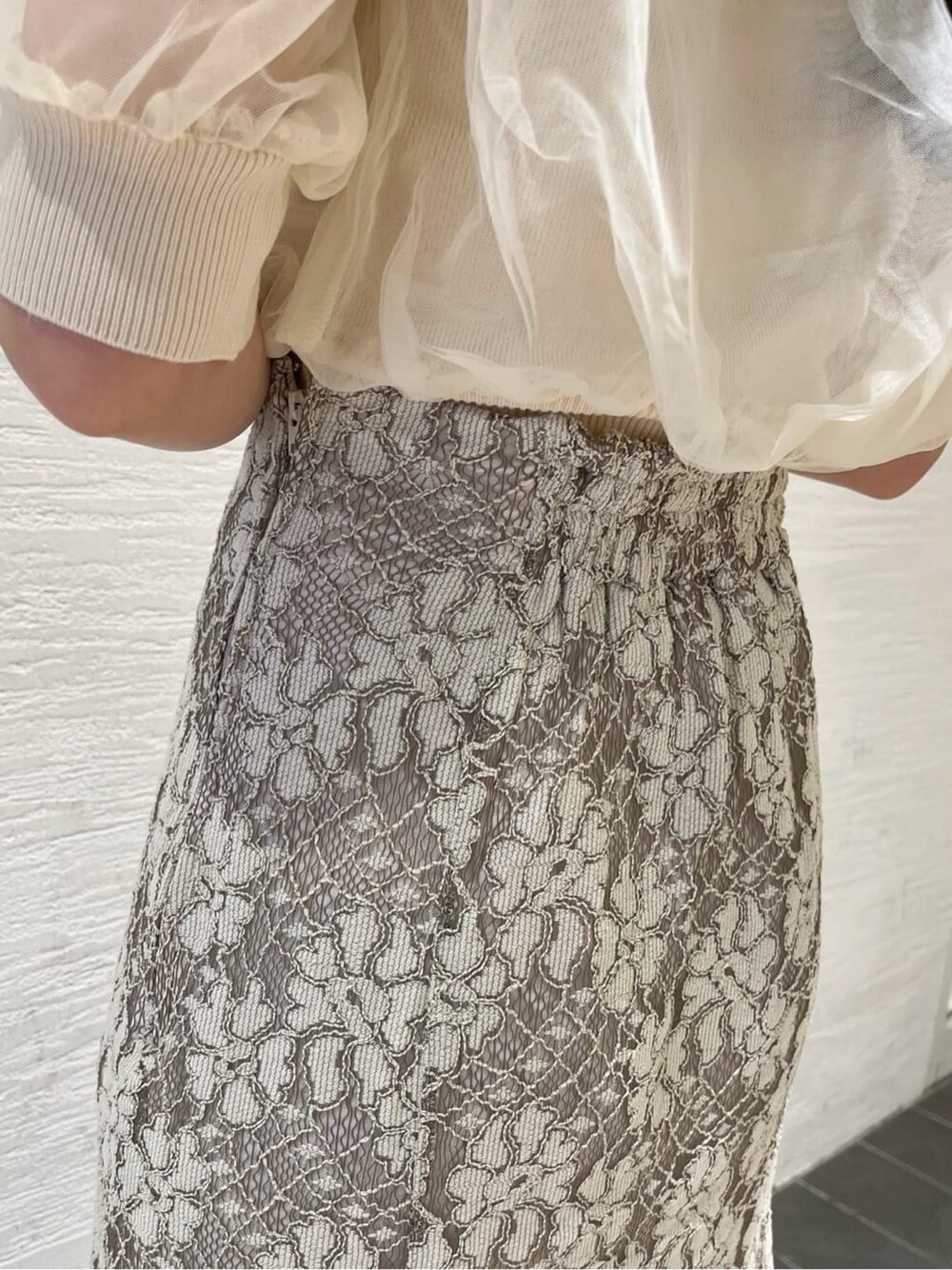 ベージュ系のスカート、ホワイト系のパンプス、ホワイト系のニット/セーターを着用したレディースの春コーディネートの9枚目の写真