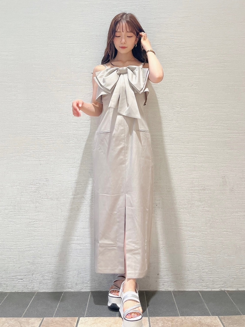 ホワイト系のサンダル、ベージュ系のワンピースを着用したレディースの夏コーディネートの2枚目の写真