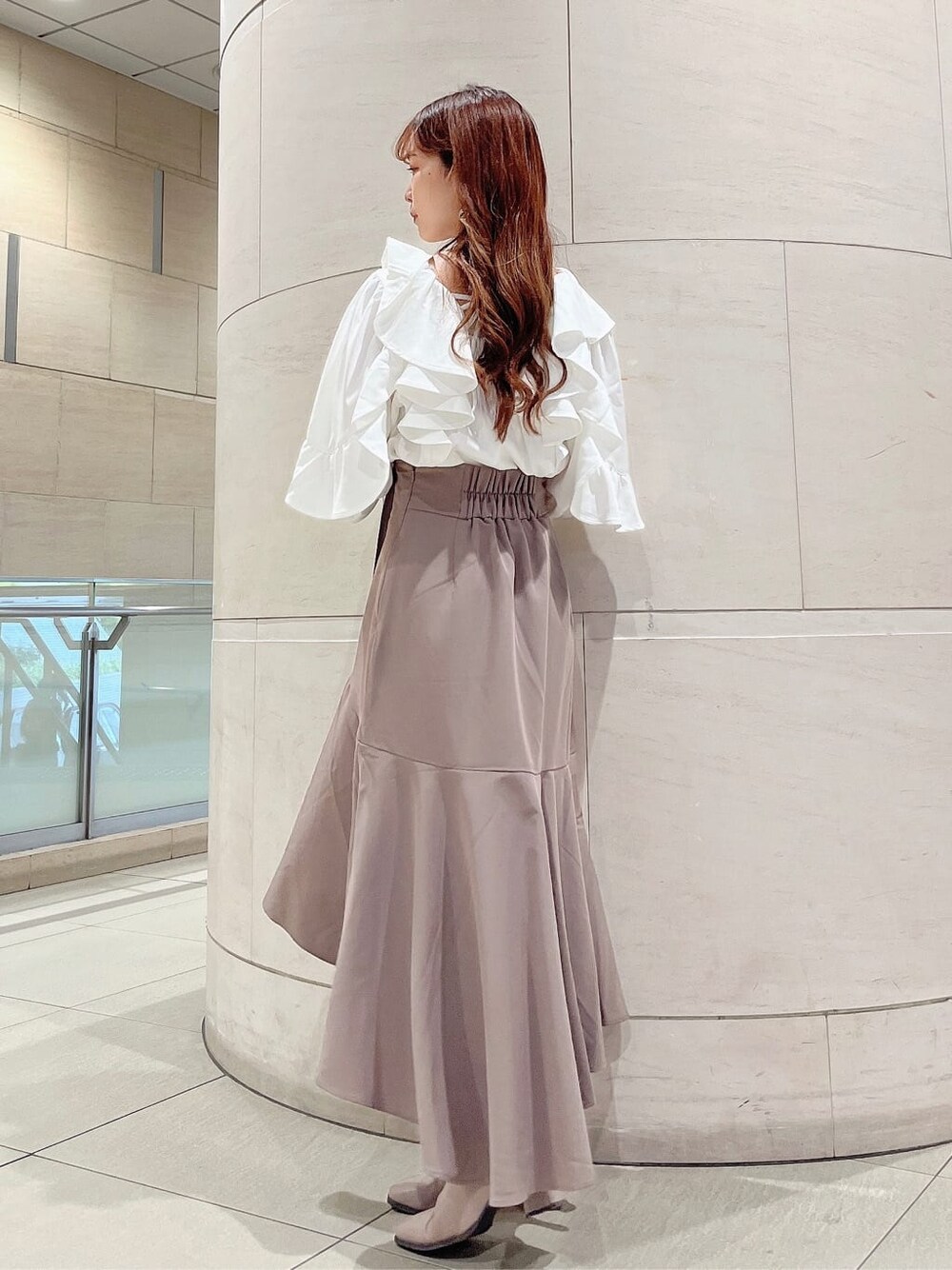 ベージュ系のブーツ、ベージュ系のスカート、ホワイト系のシャツ/ブラウスを着用したレディースの秋コーディネートの4枚目の写真