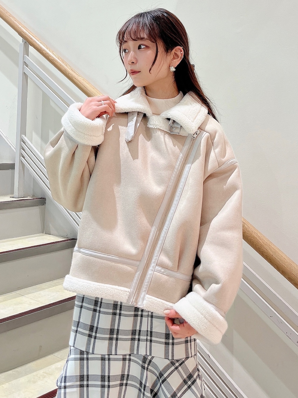 ホワイト系のブルゾン、ホワイト系のスカート、ベージュ系のブーツを着用したレディースの冬コーディネートの9枚目の写真