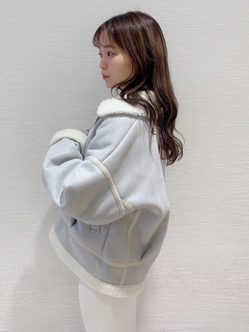 グレー系のブルゾン、ベージュ系のブーツ、ホワイト系のワンピースを着用したレディースの秋コーディネートの7枚目の写真