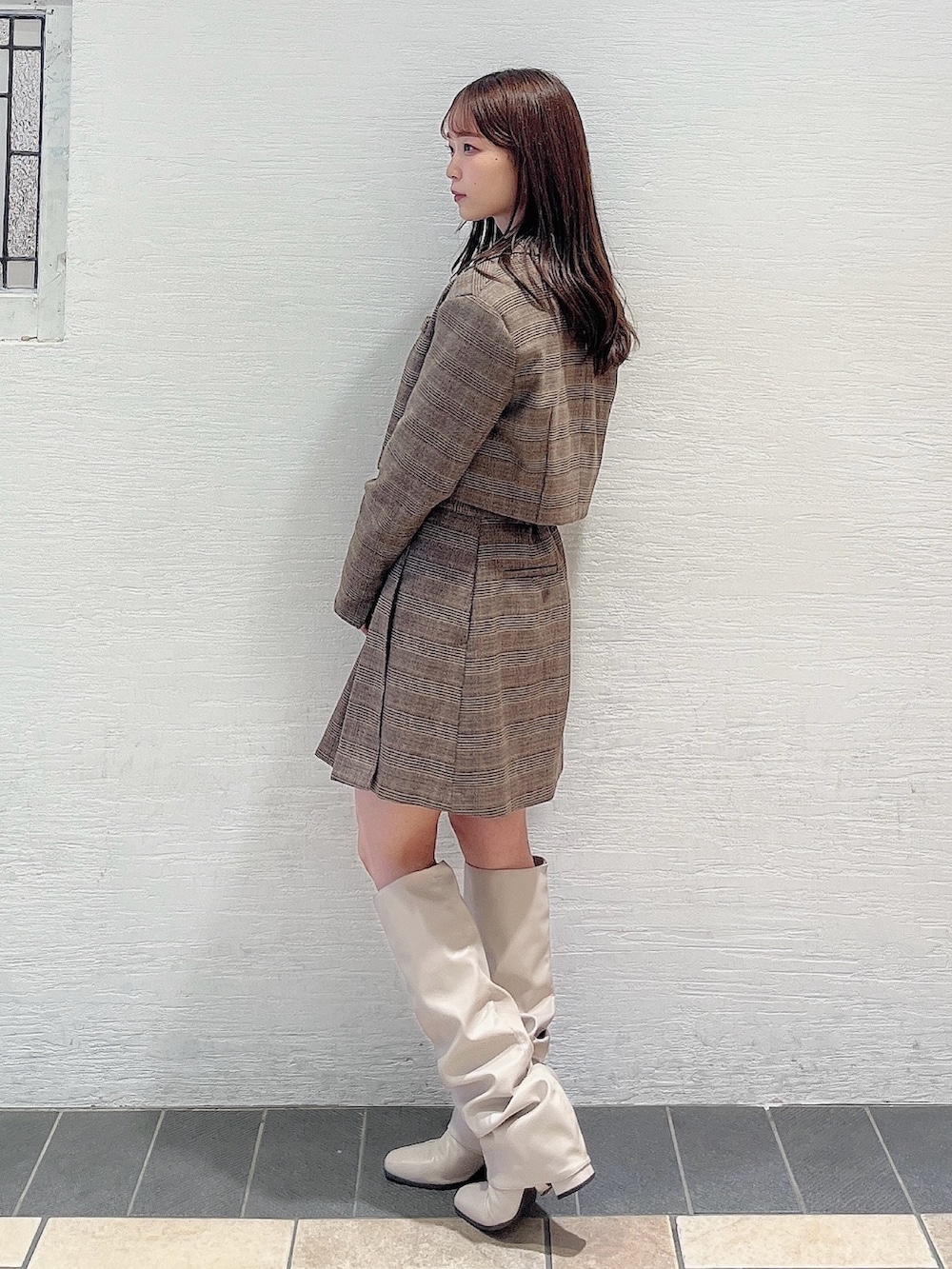 ベージュ系のブーツ、ブラウン系のスカート、ホワイト系のニット/セーターを着用したレディースの秋コーディネートの4枚目の写真