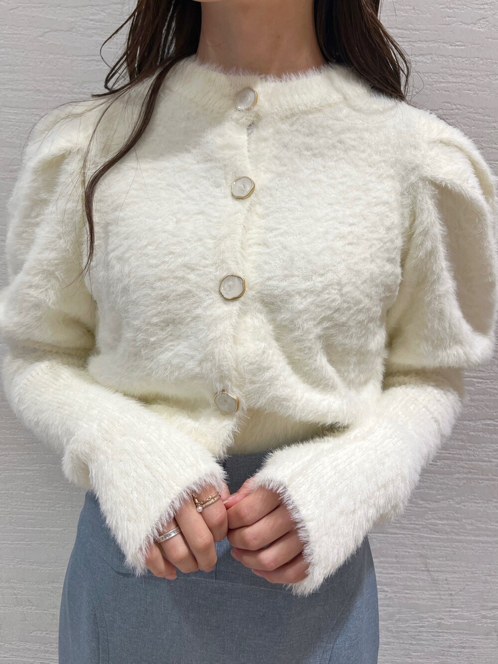 ホワイト系のニット/セーター、ブルー系のスカート、ベージュ系のブーツを着用したレディースの冬コーディネートの7枚目の写真