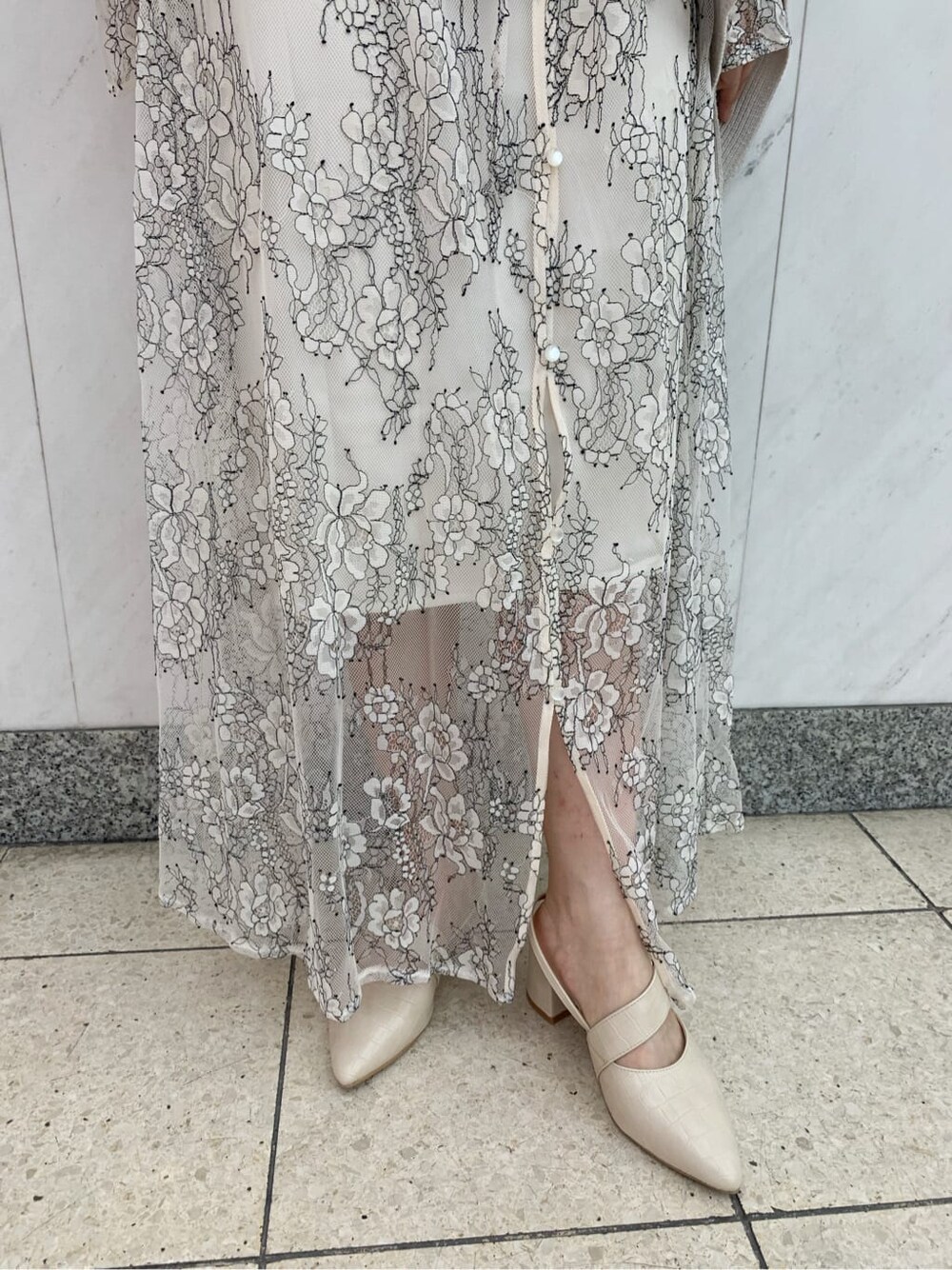 ホワイト系のワンピース、ベージュ系のニット/セーター、ホワイト系のパンプスを着用したレディースの秋コーディネートの10枚目の写真