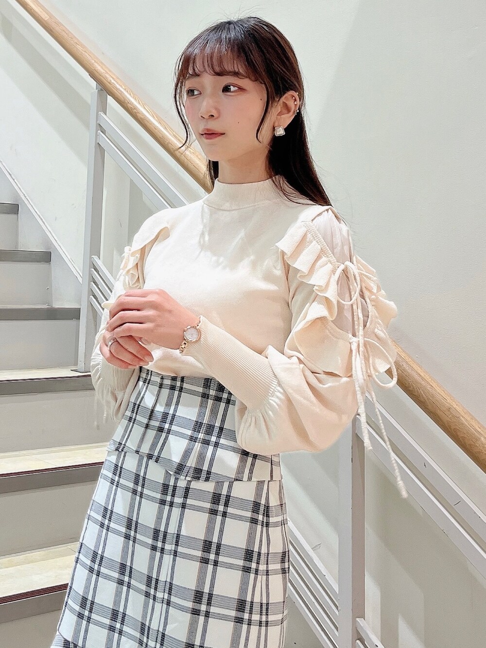 ホワイト系のニット/セーター、ホワイト系のスカート、ベージュ系のブーツを着用したレディースの冬コーディネートの8枚目の写真