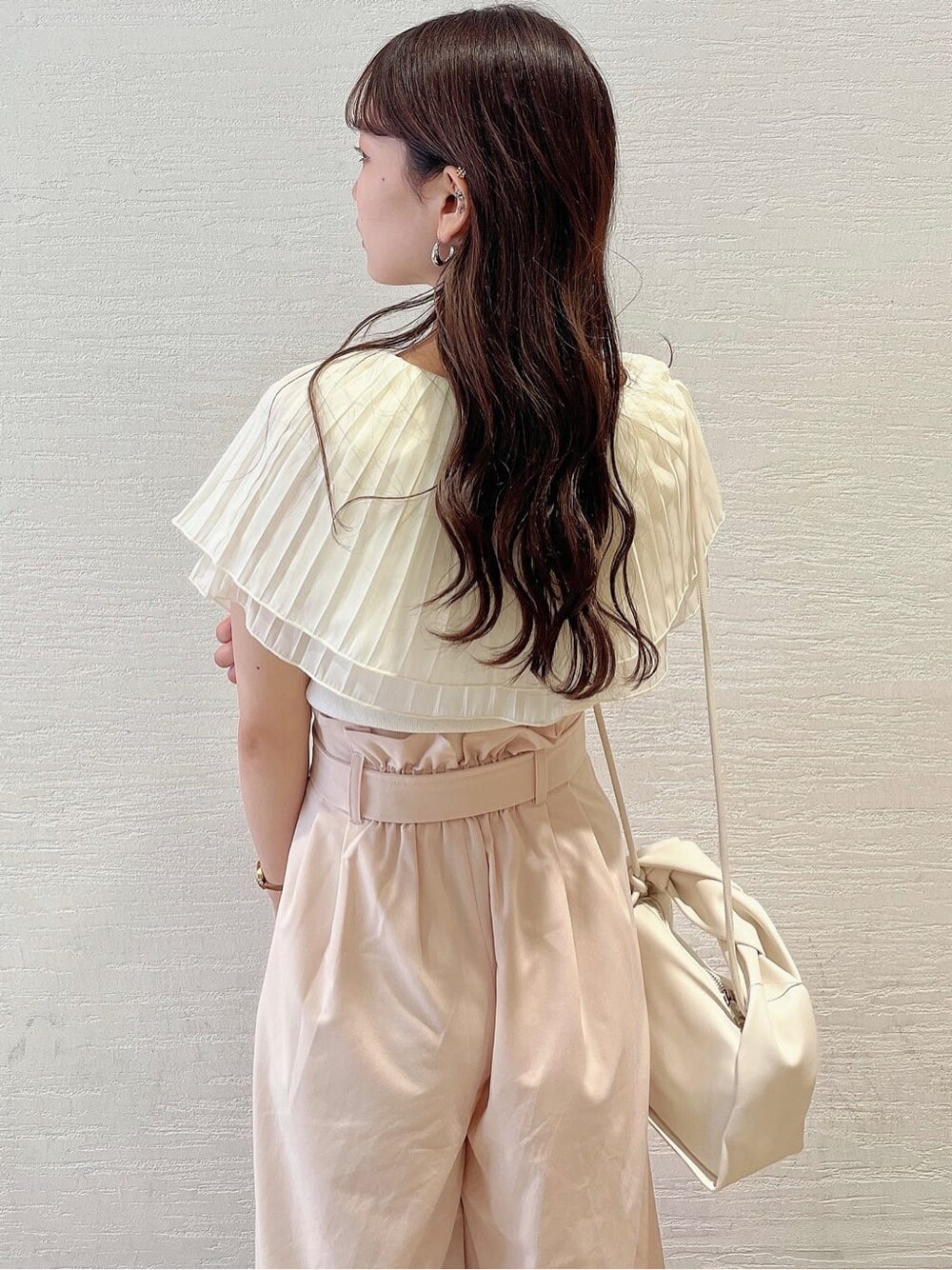 ベージュ系のその他パンツ、ホワイト系のサンダル、ホワイト系のニット/セーターを着用したレディースの夏コーディネートの5枚目の写真