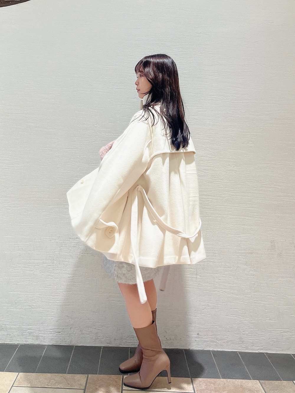 ベージュ系のブーツ、ホワイト系のダッフルコート、ピンク系のニット/セーターを着用したレディースの秋コーディネートの3枚目の写真